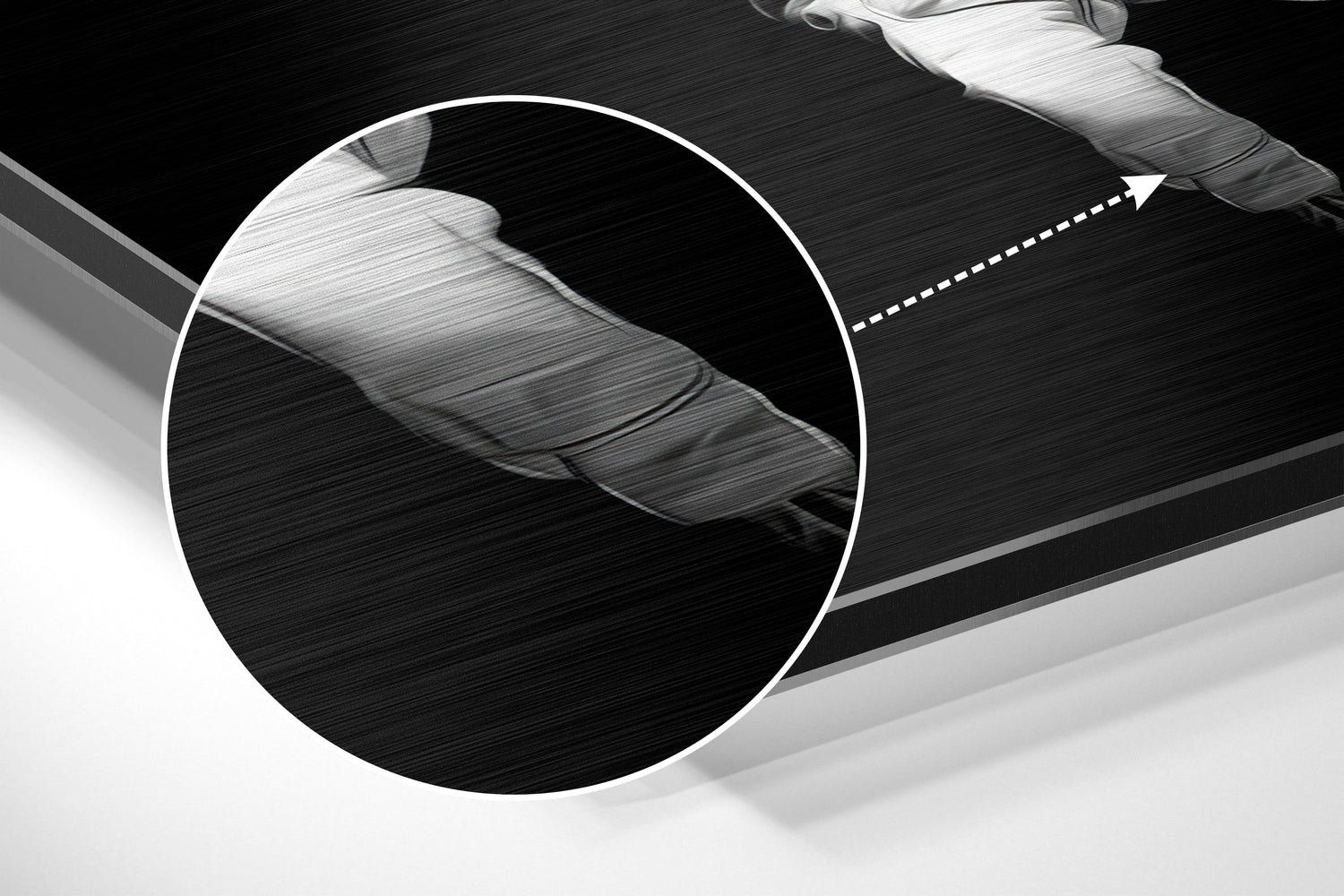 Close-up detail of brushed aluminum surface showing textured finish and white circular magnified section highlighting material grain pattern.
