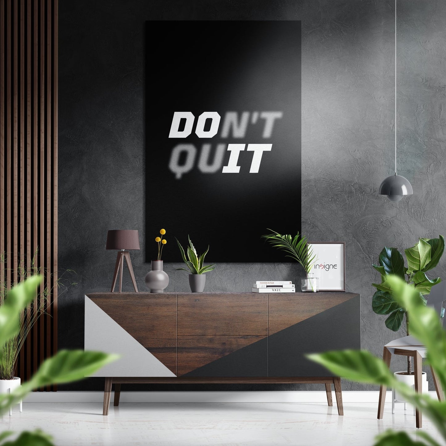Modern interior setting featuring "DON'T QUIT" motivational text on black brushed aluminium wall art above wooden console table.