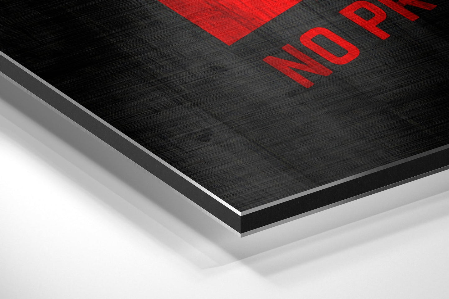 Close-up angled view of layered black brushed aluminum and white material with red text reading "NOPE" at top edge.