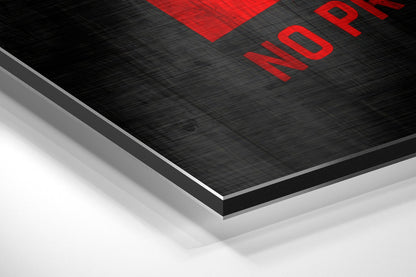 Close-up angled view of layered black brushed aluminum and white material with red text reading "NOPE" at top edge.