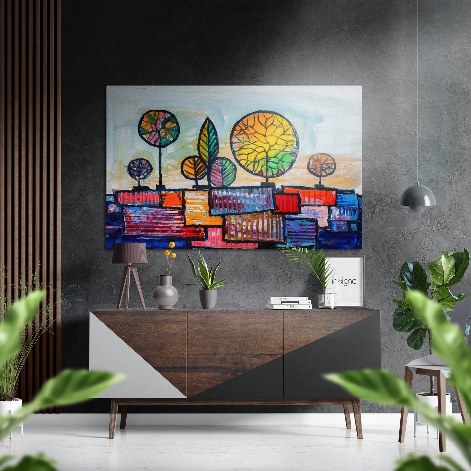 Colorful abstract wall art with stylized trees and geometric cityscape displayed above a wooden mid-century console in a modern interior setting.