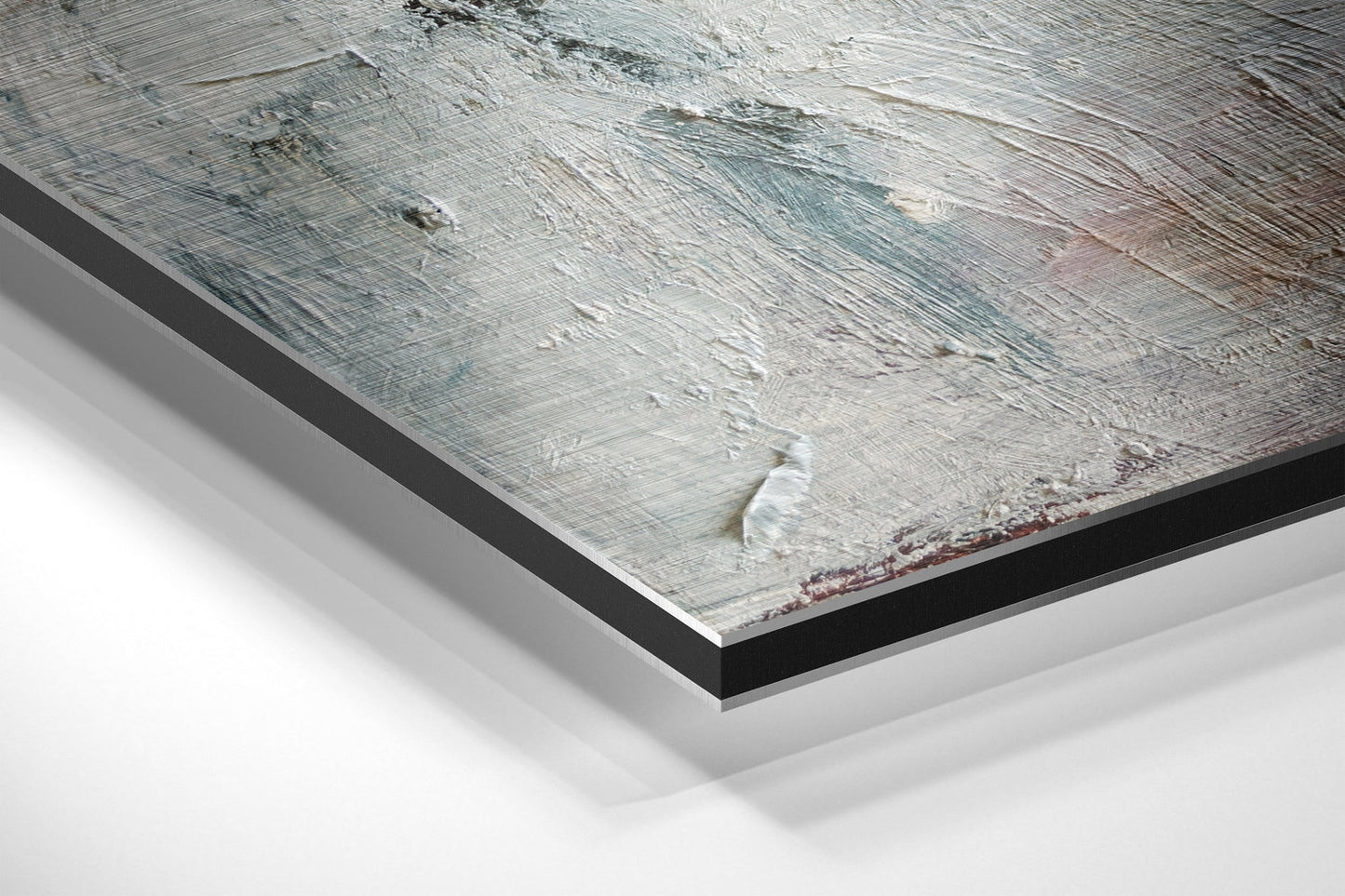 Close-up angled view of brushed aluminum Dibond wall art with black border, showing textured gray and white surface with red accents.