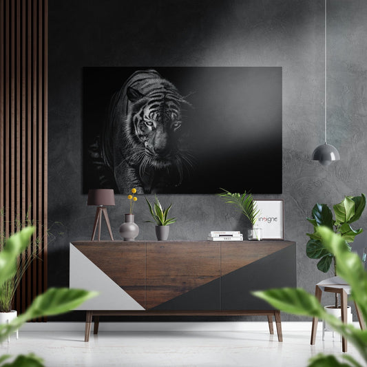 Black and white tiger portrait mounted on grey wall above wooden dresser with plants and decorative items in modern interior setting.