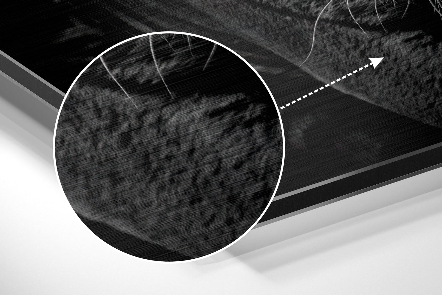 Close-up detail of brushed aluminium surface with circular white outline and directional arrow on black and gray abstract background.