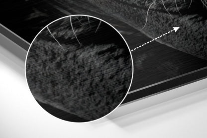 Close-up detail of brushed aluminium surface with circular white outline and directional arrow on black and gray abstract background.