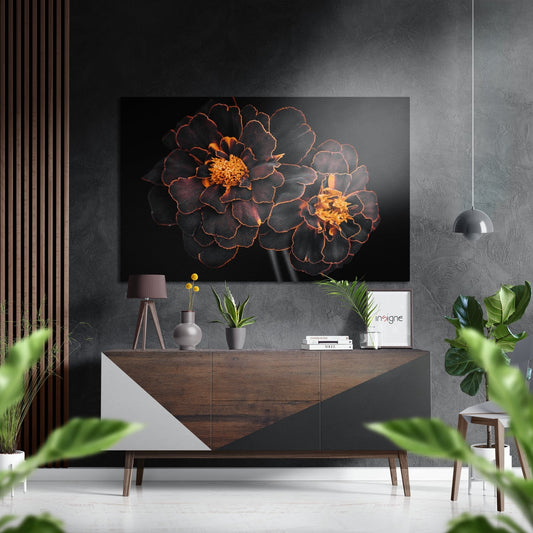 Dark red and gold flowers on black background displayed above wooden console table in modern interior setting.
