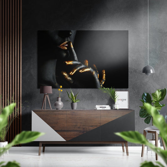 Modern living room interior featuring gold lips and fingers artwork on dark wall above wooden sideboard with plants and accessories.