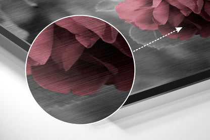 Close-up detail of brushed aluminium surface with pink rose petals and magnified circular view showing texture.