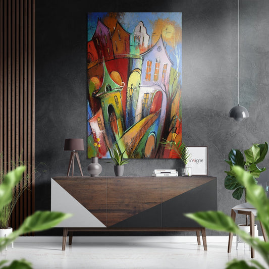 Colorful whimsical houses artwork displayed above wooden console table in modern interior with plants and pendant lamp.