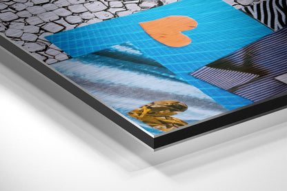 Angled side view of brushed aluminium Dibond wall art with blue background, orange heart shape, and textured animal details visible on layered mounting system.