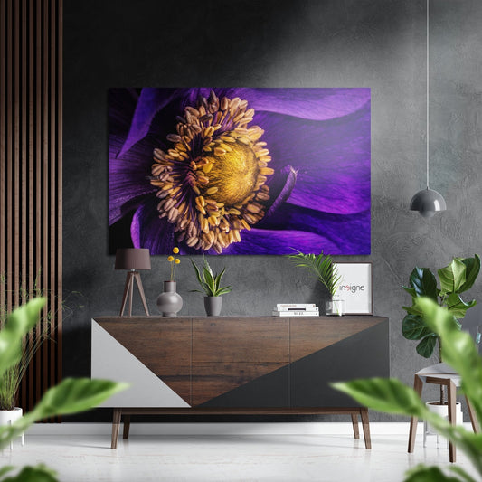 Purple flower artwork with golden yellow center displayed above wooden console table in modern interior setting.