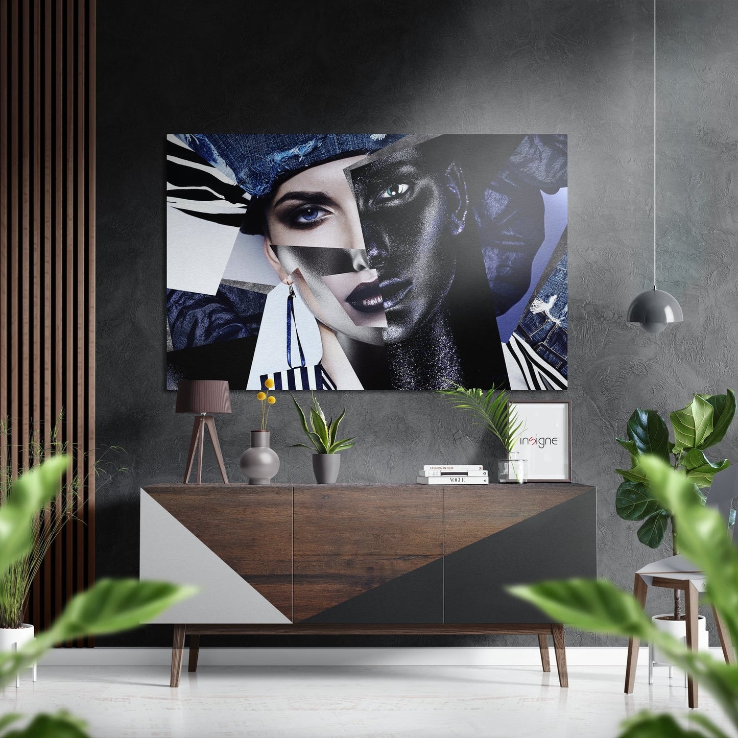 Modern interior with brushed aluminum wall art featuring abstract split faces in blue, black, and white tones mounted above wooden console table with plants and pendant lamp.