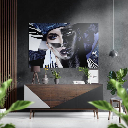 Modern interior with brushed aluminum wall art featuring abstract split faces in blue, black, and white tones mounted above wooden console table with plants and pendant lamp.