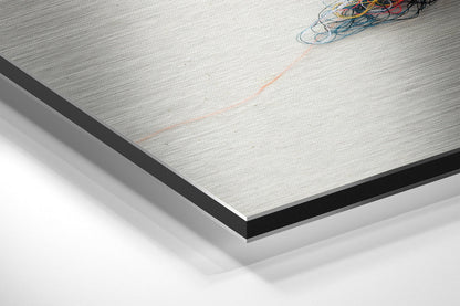 Close-up angled view of Sparrow Brushed Aluminium Dibond panel showing metallic surface texture with black edge trim and bundled wires.