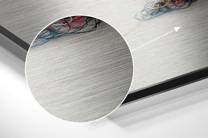 Close-up detail of brushed aluminium surface texture with multicolored electrical wires visible at top edge.