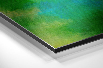 Close-up angled view of layered Dibond panel edges showing green gradient artwork surface with black and gray aluminum borders.