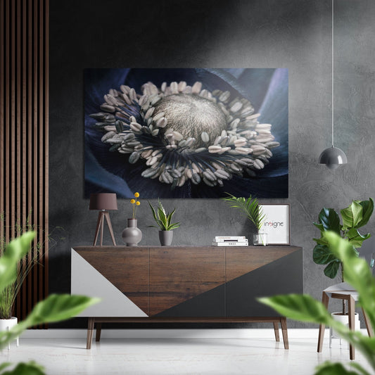 Pale ivory flower with prominent stamens displayed as wall art above a wooden console table in a modern interior setting.