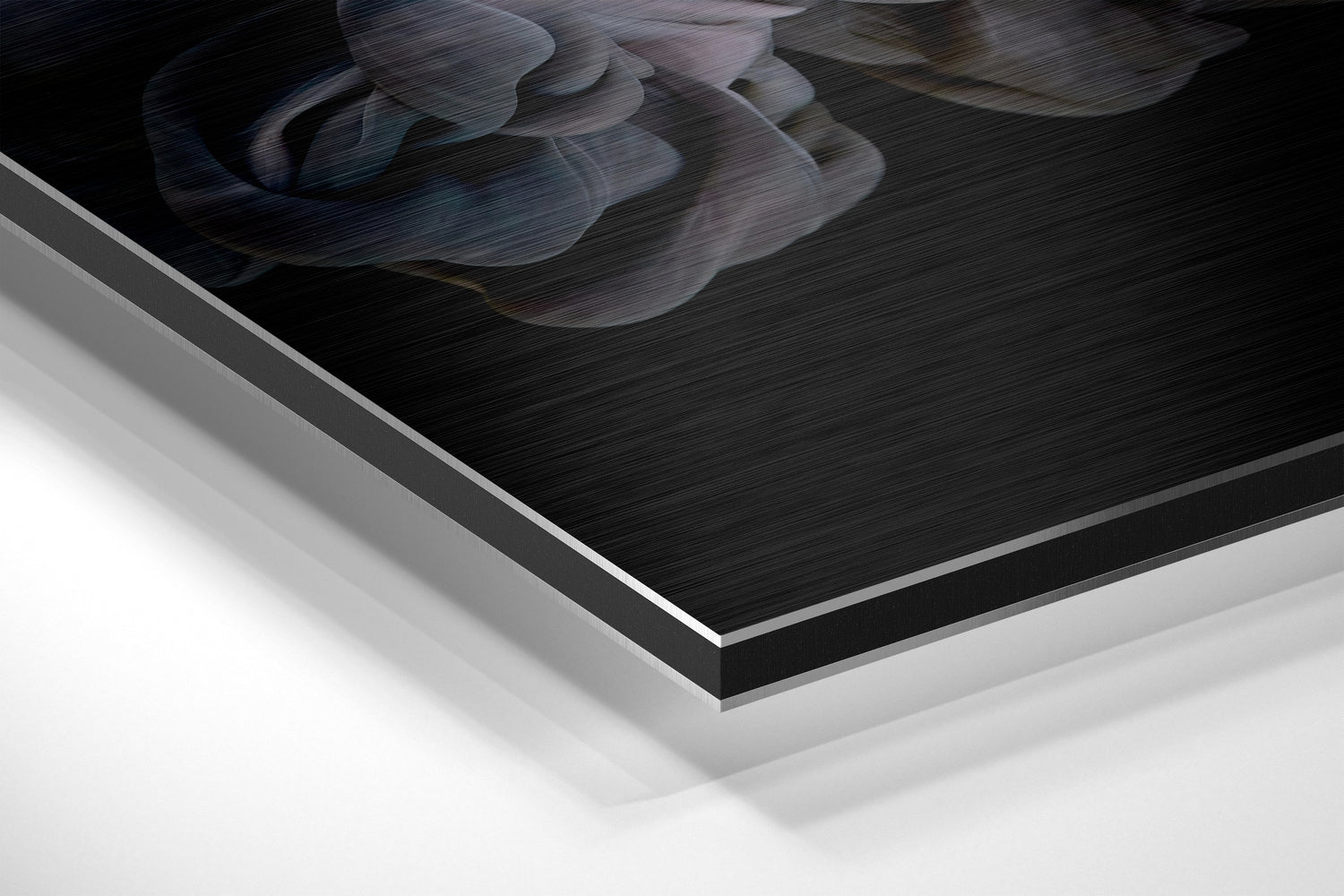Close-up angled view of layered Dibond panel showing brushed black aluminium surface with white backing layers and subtle blue-grey abstract swirls.