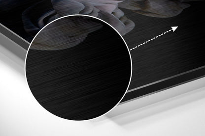 Close-up angled view of brushed aluminium Dibond wall art with circular white-bordered design and directional arrow detail on dark textured surface.
