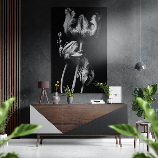 Black and white brushed aluminium wall art of tulips displayed above a wooden dresser in a modern interior setting.