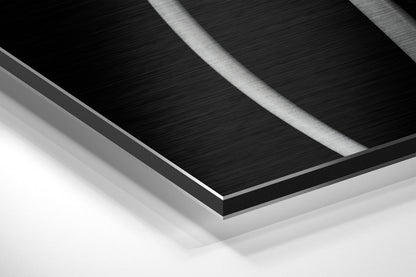 Close-up angled view of layered brushed aluminum and black Dibond panel edges showing metallic surface texture and depth.