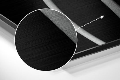 Abstract close-up of brushed aluminium wall art showing white circle outline and directional arrow on layered textured surfaces.
