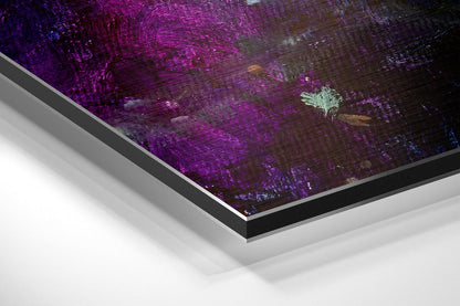 Angled corner view of framed brushed aluminium wall art featuring purple and dark abstract textured surface with white border detail.