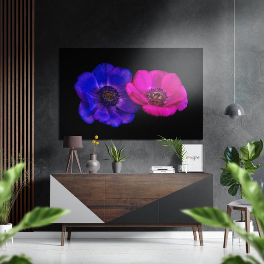 Modern living room with violet and pink anemone flowers displayed on wall above wooden console table with décor.