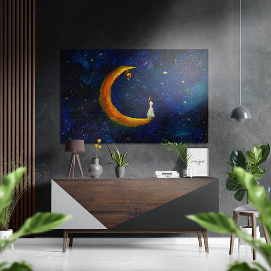 Modern interior room with wooden console table displaying "Moonfall" artwork featuring golden crescent moon and figure against starry night sky above potted plants and decor.