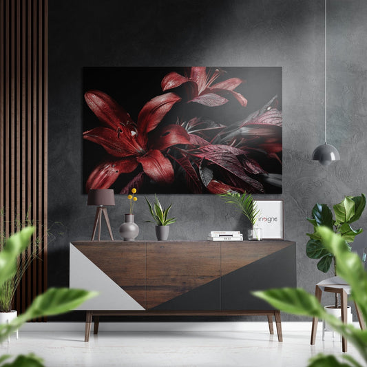 Red lily Dibond wall art displayed above a wooden console table in a modern interior setting with plants and pendant lighting.