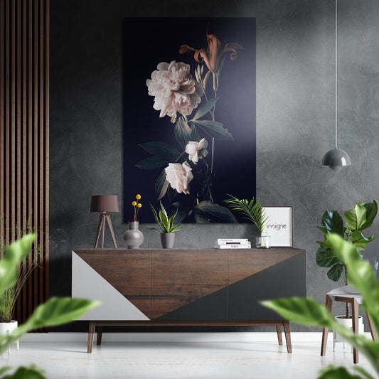 White peony artwork on dark background displayed above wooden console in modern interior with plants and pendant light.