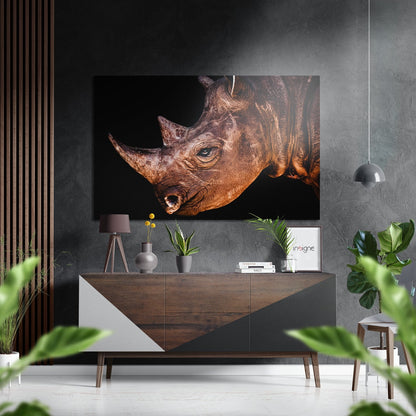 Brushed aluminium Dibond artwork depicting a brown rhinoceros profile against black background, displayed above wooden dresser in modern interior.