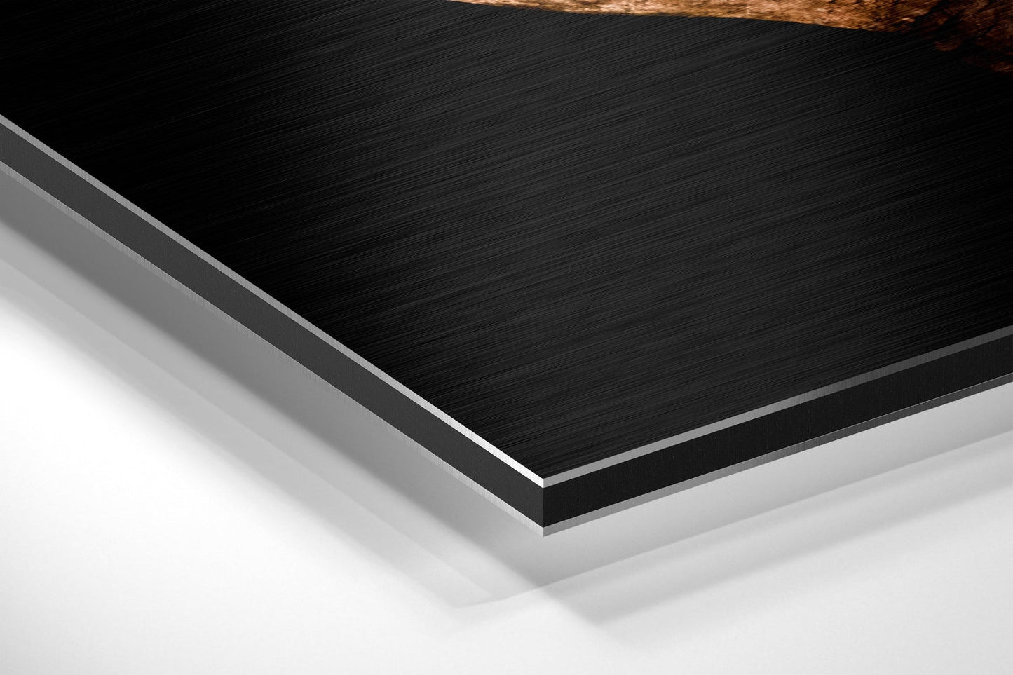 Close-up angled view of layered Dibond wall art showing brushed black aluminum surface with silver edge trim and white backing material.