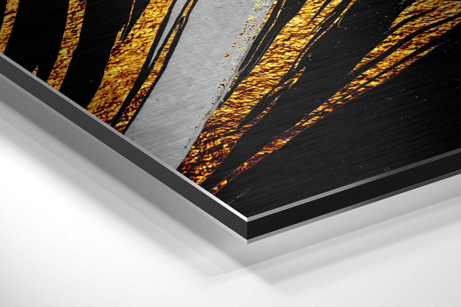 Close-up angled view of layered Dibond print showing gold and black feather design with brushed aluminum surface and white mounting edge.