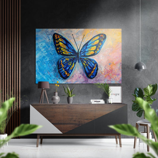 Blue and yellow butterfly painting hung above wooden console table in modern gray interior with plants and pendant light.