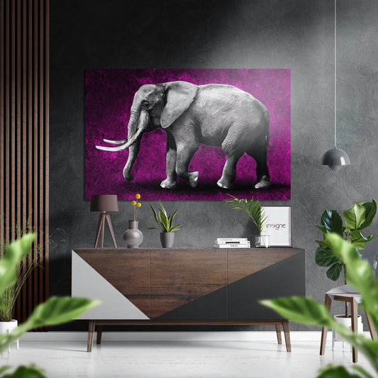 Gray elephant with white tusks on vibrant magenta background mounted above wooden console table in modern interior setting.