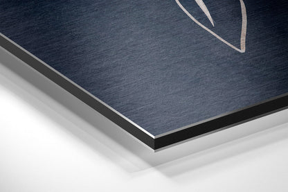 Close-up angled view of brushed aluminum dibond panel showing dark blue textured surface with black and gray layered edges.