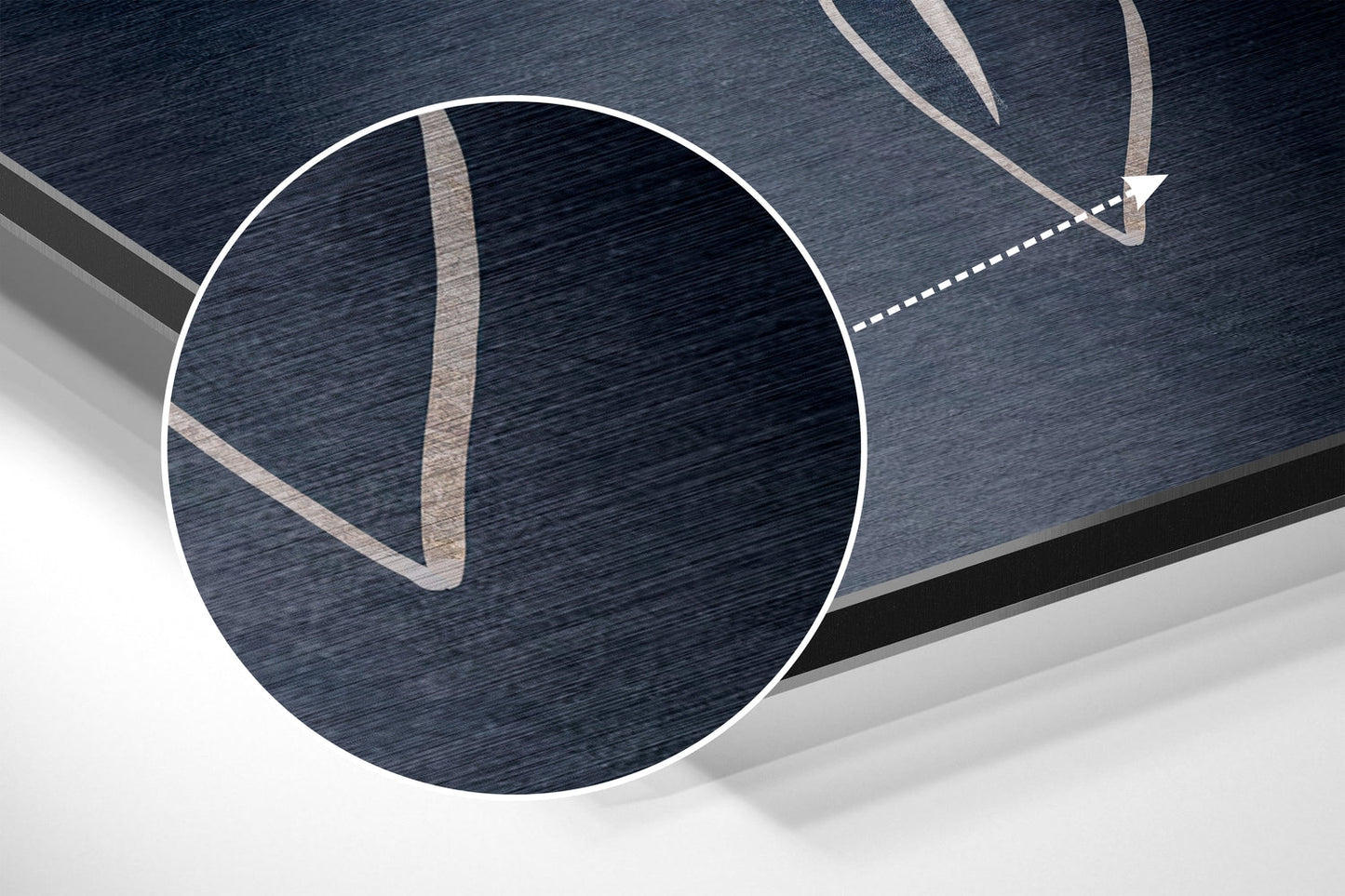 Close-up detail of brushed aluminum Dibond surface showing tan and dark blue striped pattern with circular magnification window.