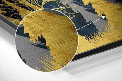 Close-up angled view of Golden Forest Dibond art showing magnified brushed aluminum texture with gold and dark blue forest silhouettes.