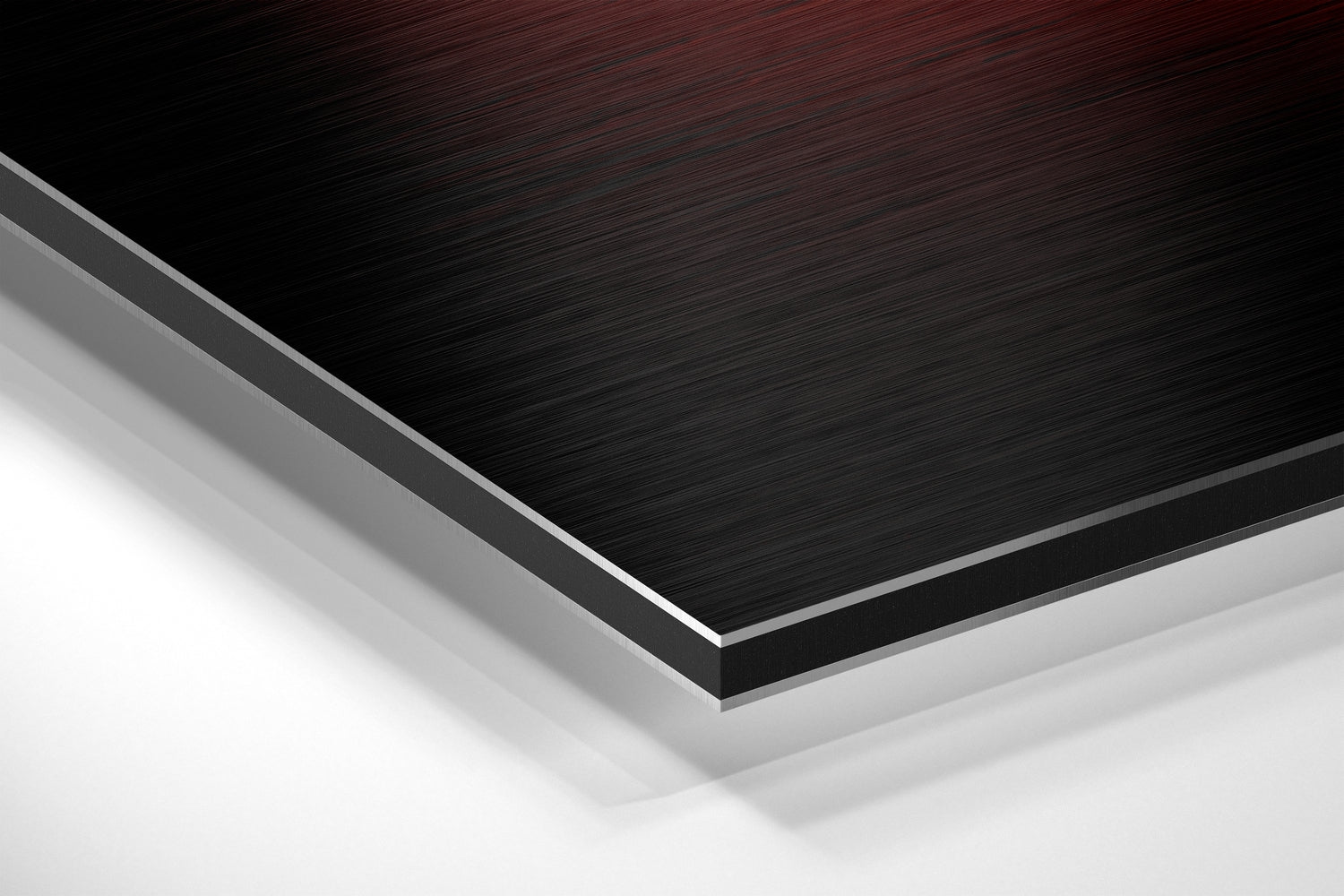 Close-up angled view of layered Dibond material showing brushed black aluminum surface with gray and white composite layers beneath.