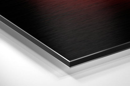 Close-up angled view of layered Dibond material showing brushed black aluminum surface with gray and white composite layers beneath.