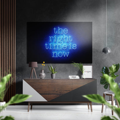 Modern living room with neon blue "the right time is now" sign mounted above wooden dresser with plants and accessories.