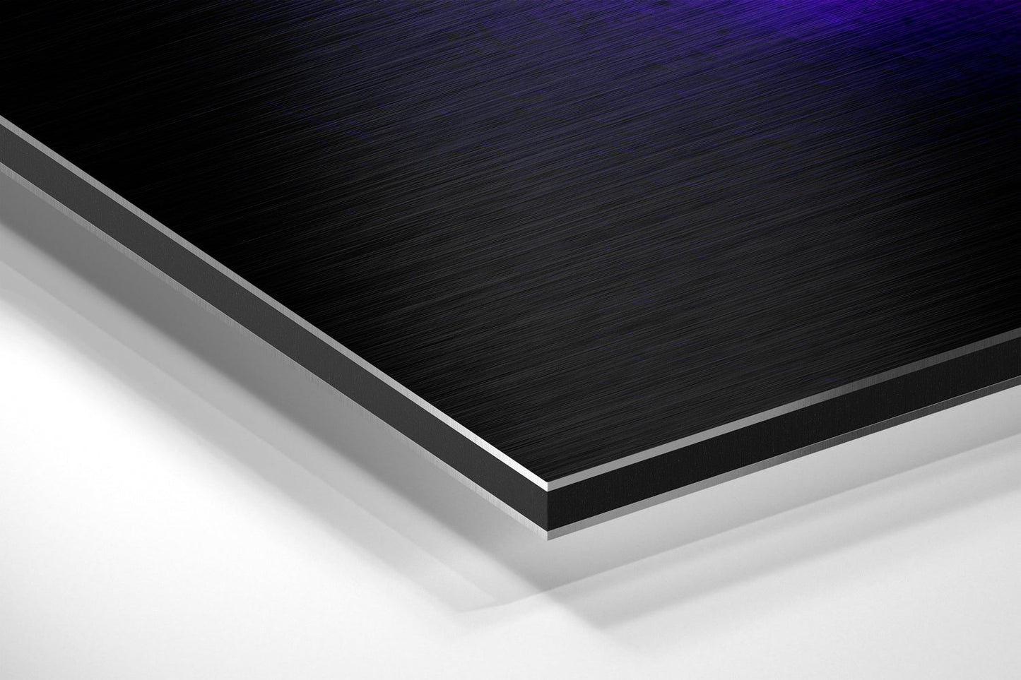 Close-up angled view of layered brushed aluminium and white core material showing edge detail and metallic surface finish.
