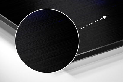 Angled close-up view of brushed aluminum wall art featuring a large black circle with white border and directional arrow on dark background.
