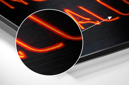 Close-up detail of brushed aluminum surface with red and yellow glowing lines creating abstract wave patterns against black background.