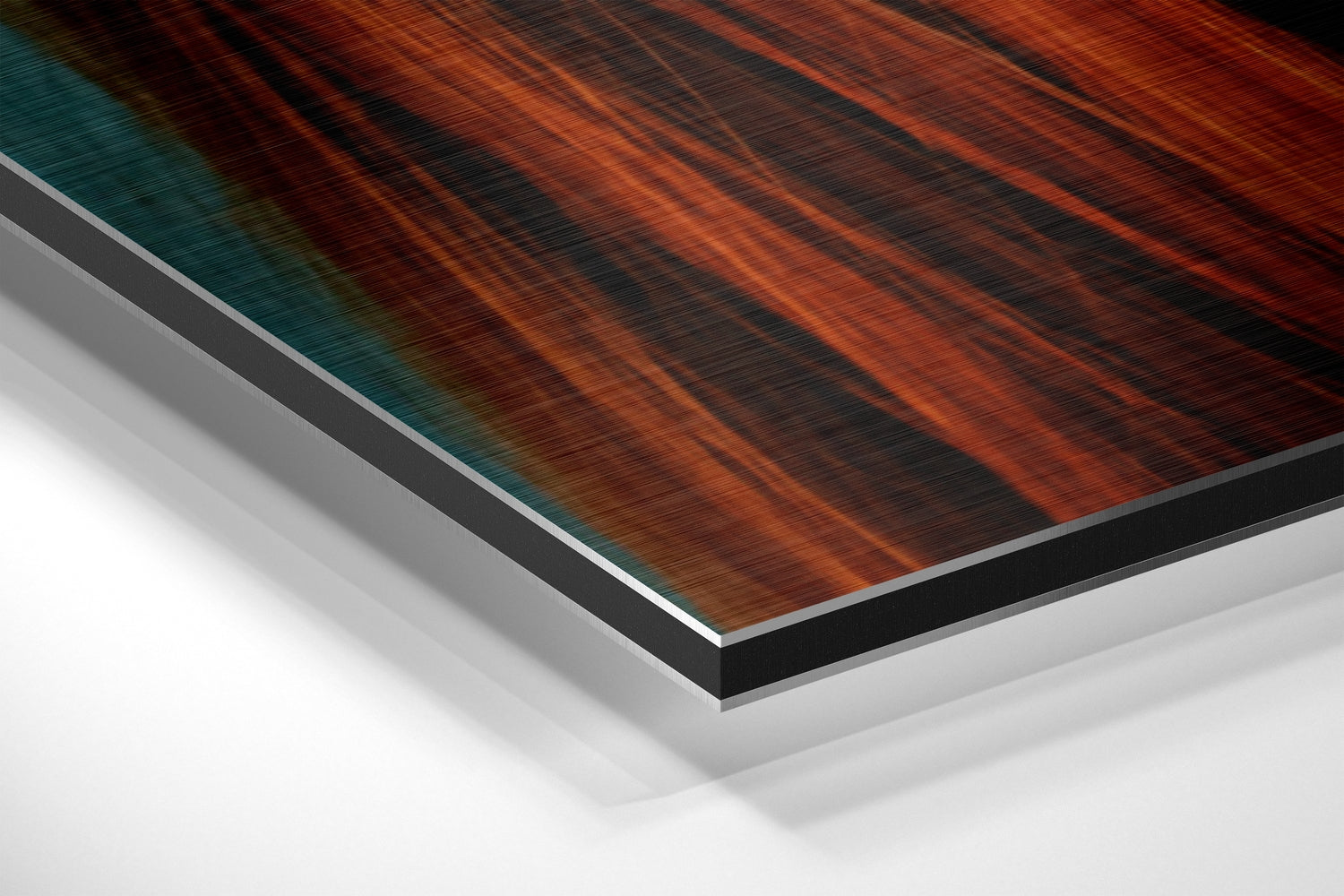 Angled close-up view of layered Dibond wall art showing brushed aluminum edge with orange and teal wood grain texture.