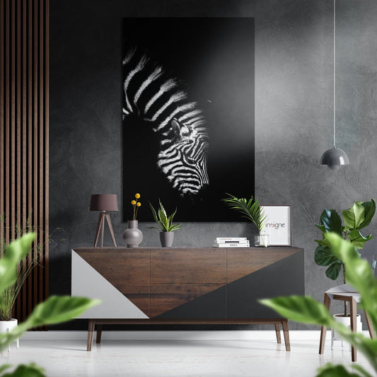 Zebra profile portrait artwork displayed above wooden console table in modern interior with plants and pendant lamp.