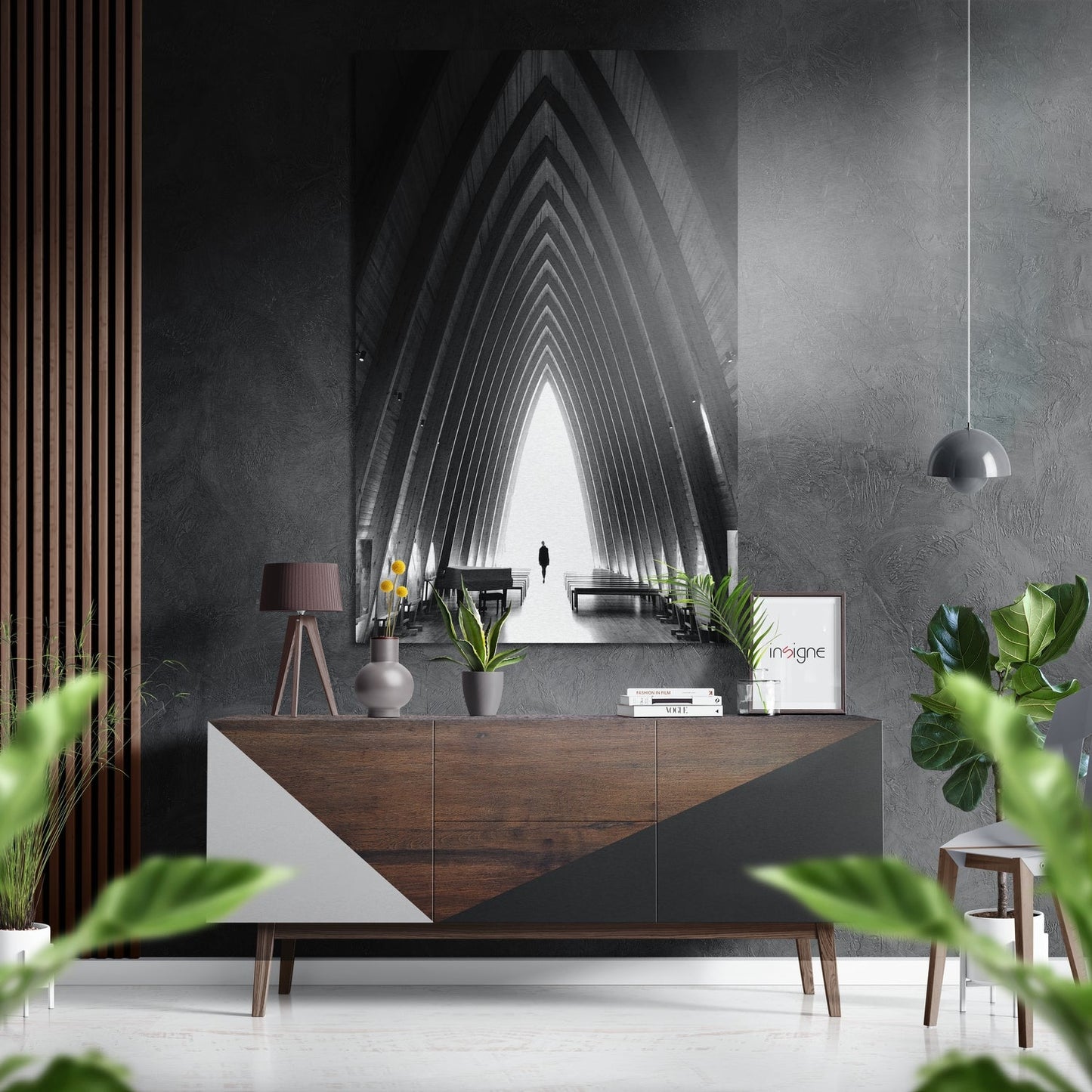 Modern interior with brushed aluminum wall art depicting symmetrical tunnel perspective above wooden dresser with plants and pendant lamp.