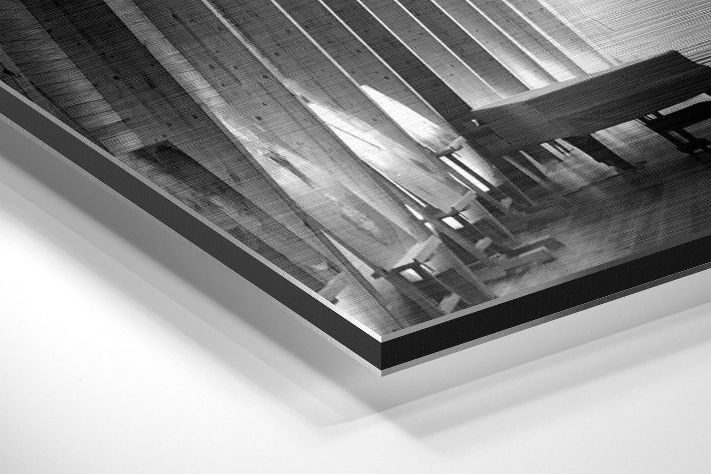 Angled perspective view of brushed aluminium Dibond print showing industrial warehouse interior with corrugated metal roof and support beams in black and white.