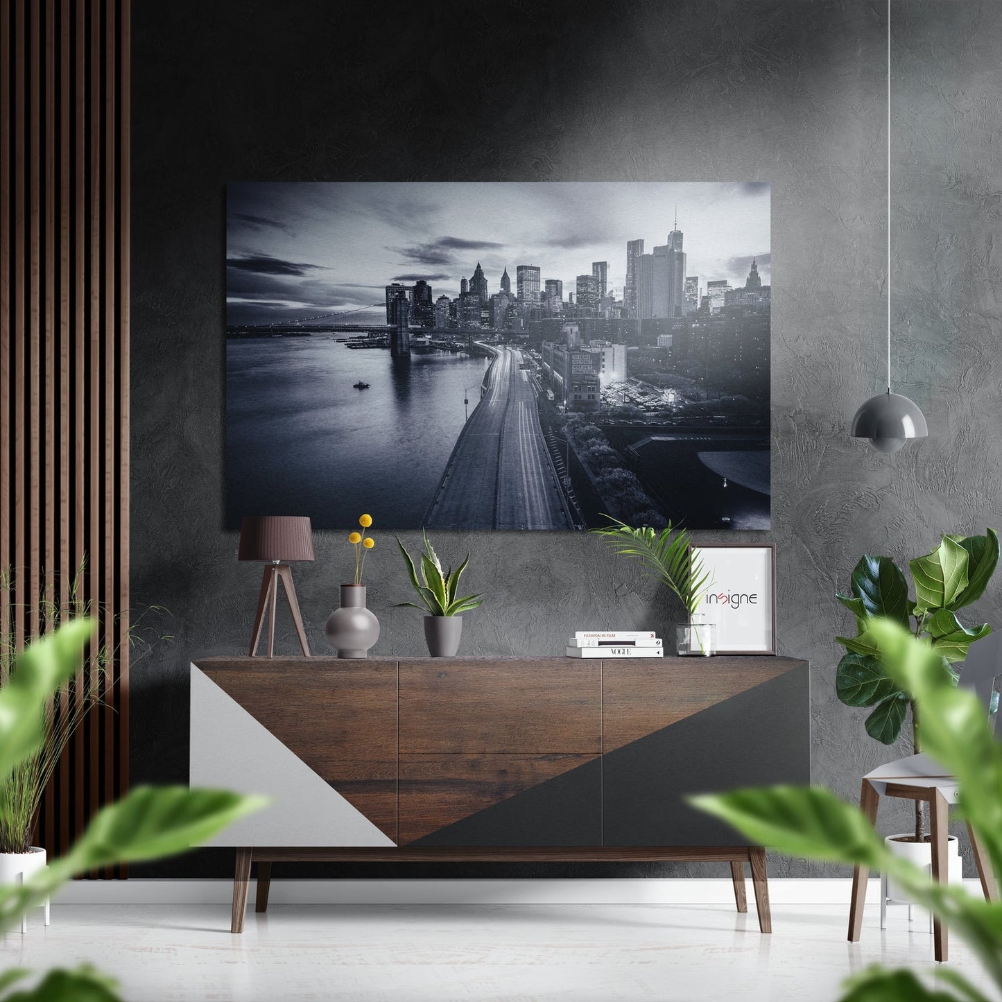 Monochrome Manhattan skyline photograph mounted on grey textured wall above wooden console table with plants and accessories.